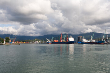 Ships are in the port on the pier against the backdrop of the mountains.