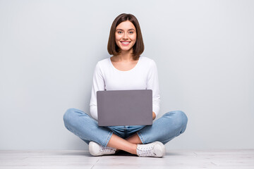 Photo of pretty sweet young lady dressed white clothes sitting legs crossed working modern device...