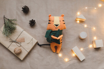 Christmas composition with a tiger toy, symbol of new 2022, a gift, fir tree branches and decorations. Christmas, winter, new year concept. Flat lay, top view