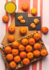 Composition of mandarin oranges and a pair of mandarin segments on a slate base and orange juice on...