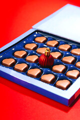 Creative Christmas concept with Christmas ball in box of heart shaped chocolates. 