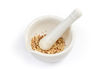 Crushed walnuts in kitchen mortar with pestle on white background