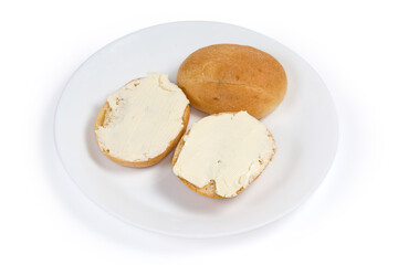 Two open sandwiches with butter and whole bun on dish