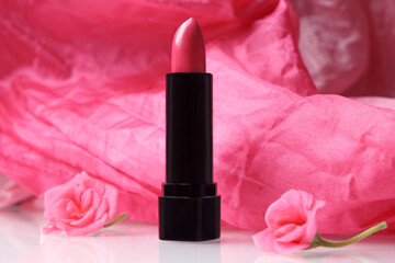 Obraz na płótnie Canvas Pink lipstick with a pelargonium flowers