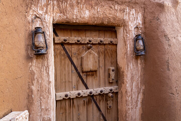 A wooden entrance gate to the traditional Arab mud brick household. Riyadh Province, Saudi Arabia