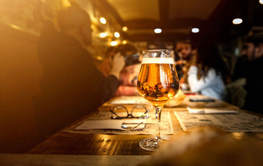Group of people having lunch at brewery bar restaurant - Close up glass beer on dining table -...