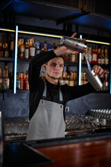 barman is making cocktail with steel shaker