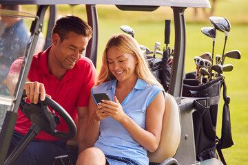 Couple Sitting In Golf Buggy On Course With Woman Using Mobile Phone - Powered by Adobe