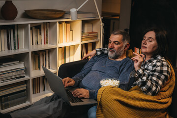 man and woman sitting on a sofa and shopping online from home