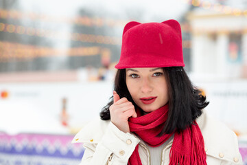Charming lady wears red cap and scarf walking at the city in winter