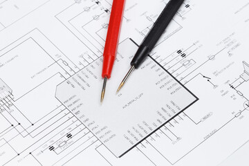 Multimeter probes on the diagram of an electronic device