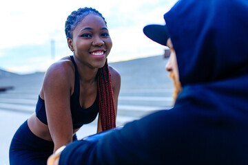 spain woman with afro pigtails crossfit trainer motivating her boyfriend for morning running outdoors in sity