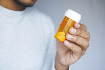 young man hand holding medicine pill container 