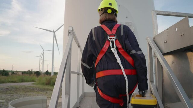Two Asian technician maintenance working on the wind turbine. Customers can choose cut between walking up and down. teamwork