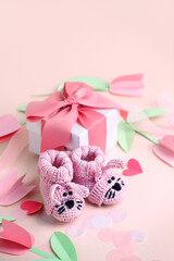 Pair of small baby socks and gift box on pink background with copy space for your warm message, baby shower, first newborn party background, copy space