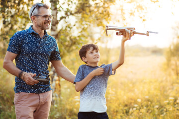 Father and son playing with flying drone in garden