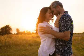 Beautiful middle-aged couple in nature. Romance and love at sunset