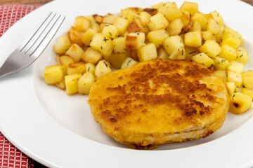 escalope frite et pommes de terre rissolées sur une assiette
