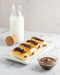 Pain au chocolat or chocolate napolitana with a bottle of milk and chocolate cream