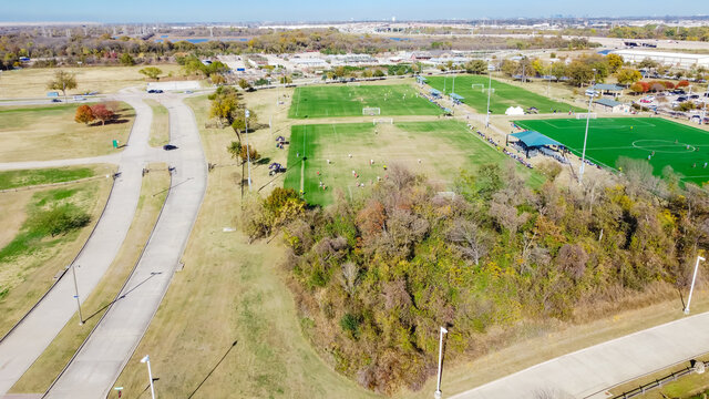 Aerial view soccer field sport complex with industrial warehouse district in background near Dallas, Texas