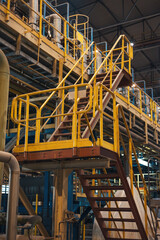 The handrail yellow stair for fire escape with the steel wall of the factory building.The factory...