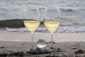 Romantic glass of white wine, on the sea beach. Wine tasting and relaxation at the resort
