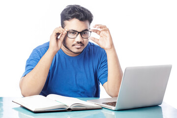 young student wearing eyeglass while studying online course on a laptop