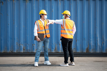 Asian male workers Elbows greet each other at the port.