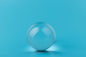 Crystal glass ball sphere transparent on blue background.