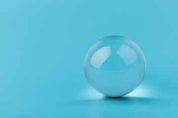 Crystal glass ball sphere transparent on blue background.