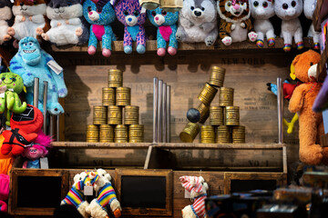 Throwing booth at the Christmas market with cans, ball and colorful plush toys as prizes, selected...