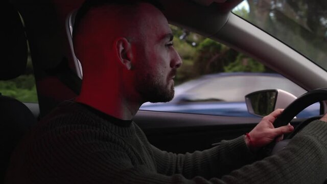 Man inside his car with police lights flashing outside