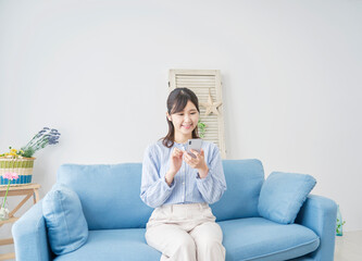 Obraz premium 女性 スマホ リビング
