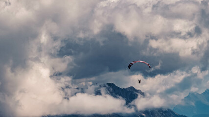 Beautiful alpine summer view with dramatic clouds and a paraglider at the famous Grubigstein summit...