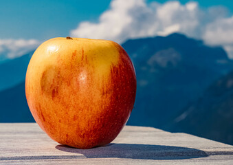 Beautiful alpine summer view with details of an apple on a table at the famous Grubigstein summit...