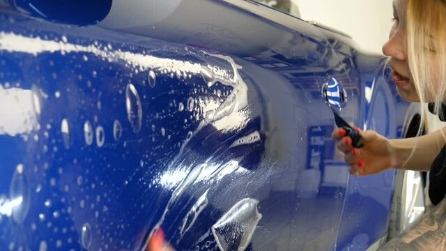 Close up to PPF installation process on a front headlight and hood. PPF is a Paint Protection Film which protect paint from scratches and stone chips. Concept of: Guard, Protect, Car, New, Work.	
