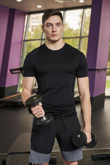 young man exercising with dumbbells in the gym