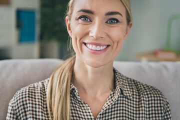 Cropped photo of optimistic pretty nice lady enjoy comfy divan smiling toothy in house apartment flat