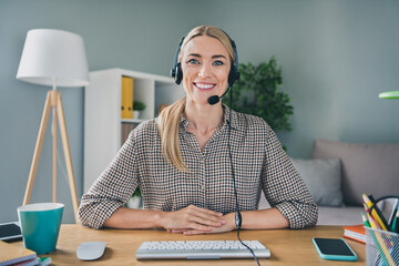 Photo of professional adviser secretary lady sit desk use mic headset video call partners in modern workspace