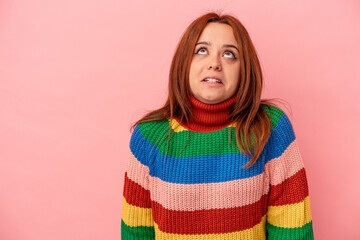 Young caucasian woman isolated on pink background shouting very angry, rage concept, frustrated.