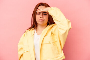 Young caucasian woman isolated on pink background touching temples and having headache.