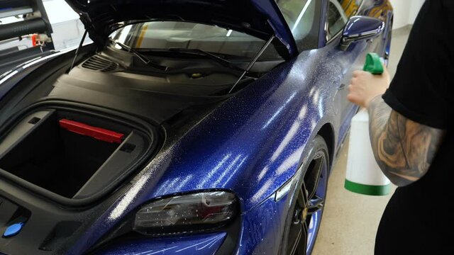 Close up to PPF installation process on a front headlight and hood. PPF is a Paint Protection Film which protect paint from scratches and stone chips. Concept of: Guard, Protect, Car, New, Work.	
