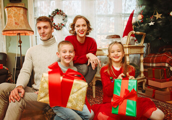 Obraz na płótnie Canvas Family celebrating Christmas together, holding presents 