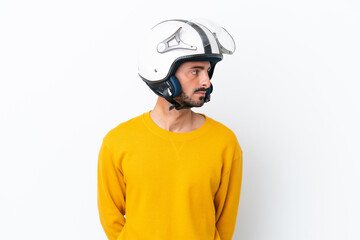 Young caucasian man with a motorcycle helmet isolated on white background looking to the side