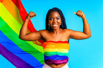 afro woman holding LGBT pride flag in blue studio background
