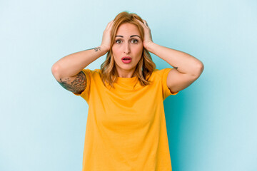 Young caucasian woman isolated on blue background being shocked, she has remembered important meeting.