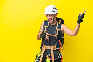 Young caucasian rock climber man isolated on yellow background making guitar gesture