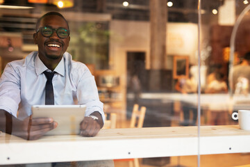 Businessman drinking coffee in cafe. Handsome African man enjoying in fresh coffee..