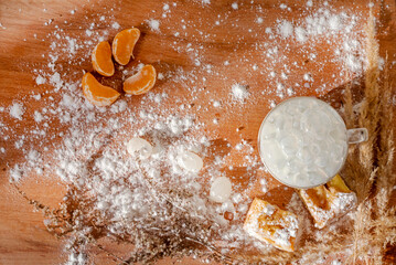 festive Christmas still life with hot drink, pie, lollipops and tangerine slices on a natural surface, new year,