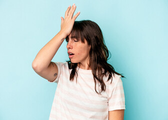 Young Argentinian woman isolated on blue background forgetting something, slapping forehead with palm and closing eyes.